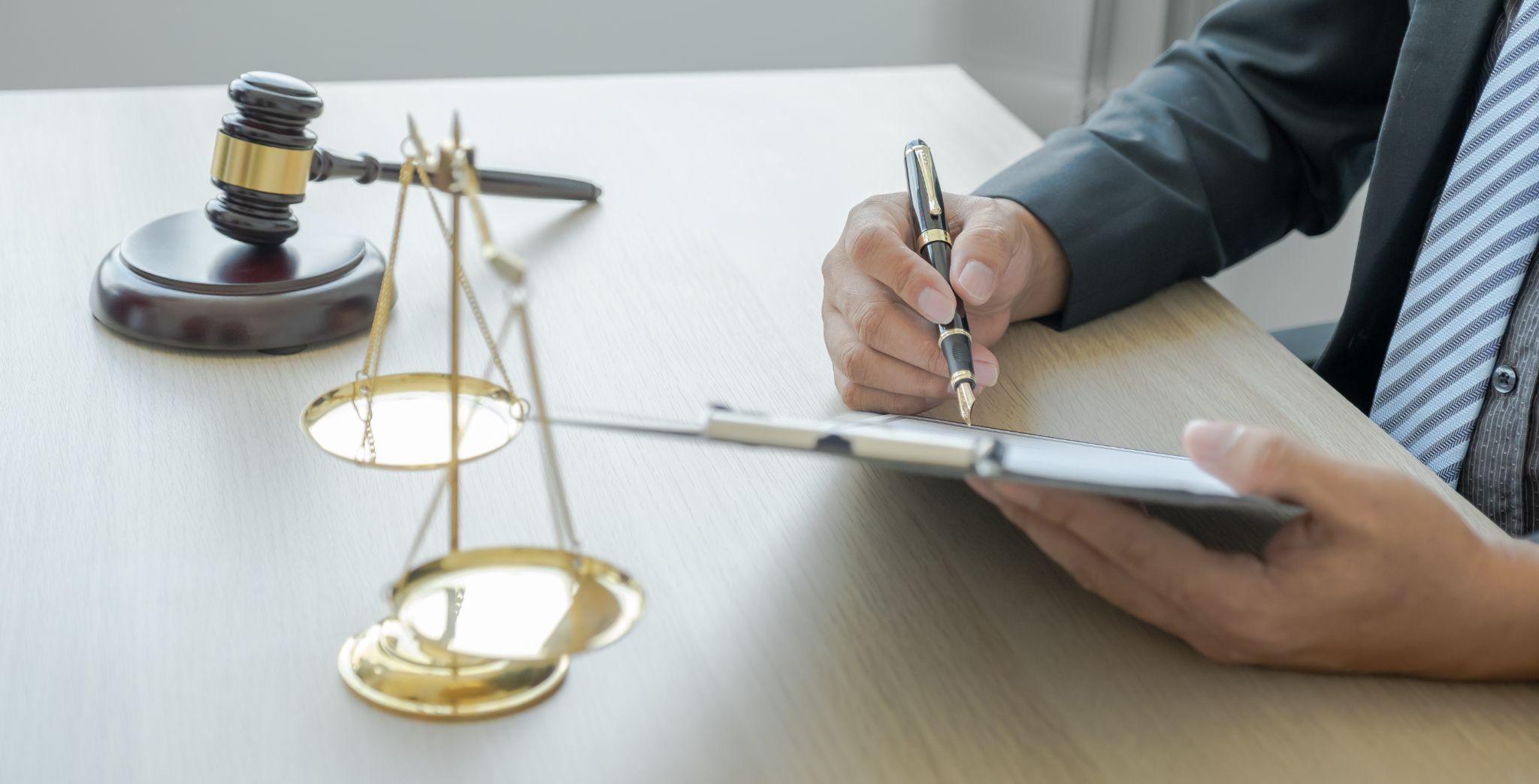 Person with pen and scale of justice discussing